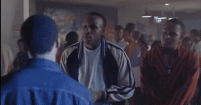 A Man In A Blue Jacket Is Standing In A Crowd GIF