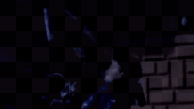 A Man In A Blue Jacket Is Standing In Front Of A Brick Wall With The Words Drai 3Ta9 GIF