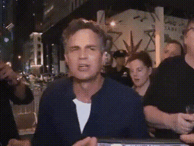 A Man In A Blue Jacket Is Standing In Front Of A Group Of People . GIF