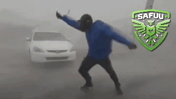 A Man In A Blue Jacket Is Standing In Front Of A White Car With A Safuu Logo Behind Him GIF