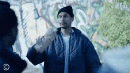A Man In A Blue Jacket Is Standing Next To A Man In A Black Hat . GIF
