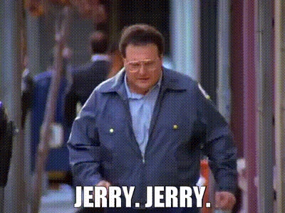 A Man In A Blue Jacket Is Walking Down A Street With The Words `` Jerry Jerry '' Written On It . GIF