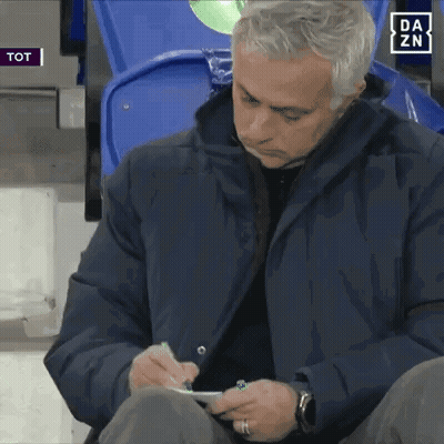 A Man In A Blue Jacket Is Writing On A Piece Of Paper With A Da Zn Logo In The Background GIF