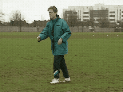 A Man In A Blue Jacket Kicking A Soccer Ball GIF