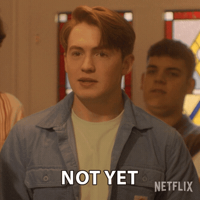 A Man In A Blue Jacket Says Not Yet In Front Of A Stained Glass Window GIF