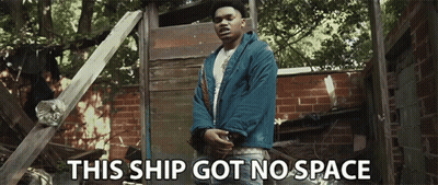 A Man In A Blue Jacket Stands In Front Of A Brick Wall With The Words This Ship Got No Space Below Him GIF