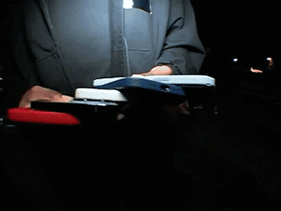 A Man In A Blue Jacket Stands In Front Of A Stadium GIF