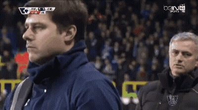 A Man In A Blue Jacket Stands Next To A Man In A Black Jacket With The Word Chelsea On It GIF