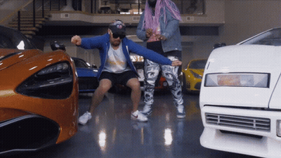 A Man In A Blue Jacket Stands Next To A Woman In Pink Hair GIF