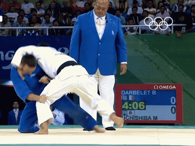 A Man In A Blue Jacket Watches A Judo Match Between Darbelet B And Ichishiba M GIF