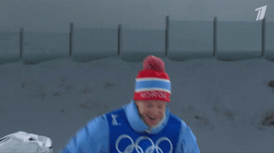 A Man In A Blue Jacket With The Word Biathlon On His Chest GIF