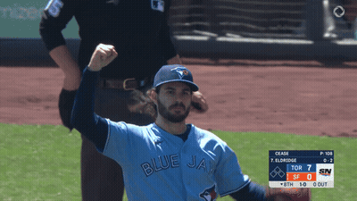 A Man In A Blue Jays Jersey Holds Up His Fist GIF