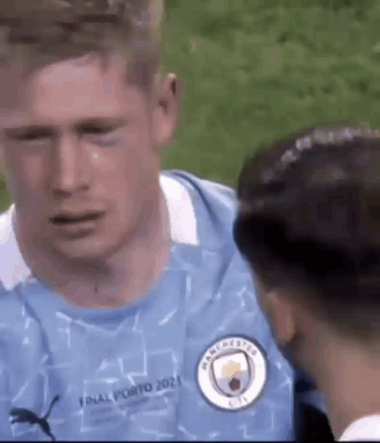 A Man In A Blue Jersey Is Crying While Talking To Another Man . GIF