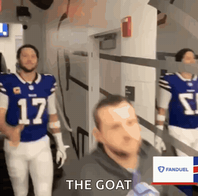 A Man In A Blue Jersey With The Number 17 On It Walks Down A Hallway GIF