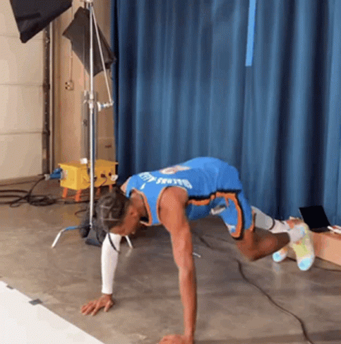 A Man In A Blue Jersey With The Word Thunder On It Is Doing Push Ups On The Floor GIF