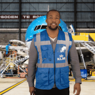 A Man In A Blue Klm Vest Stands In Front Of A Plane GIF