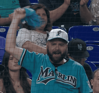 A Man In A Blue Marlins Jersey Is Cheering GIF