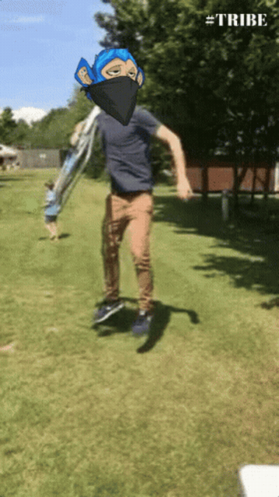 A Man In A Blue Mask Is Jumping In The Air With The Hashtag #Tribe Visible GIF