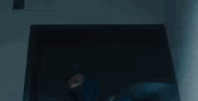 A Man In A Blue Mask Is Standing In Front Of A Glass Door . GIF
