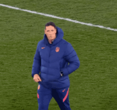A Man In A Blue Nike Jacket Stands On A Field GIF
