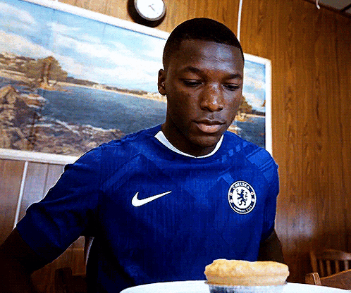 A Man In A Blue Nike Shirt Looks At A Pie GIF