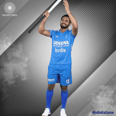 A Man In A Blue Odisha Jersey Holds Up A Hockey Stick GIF