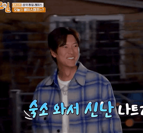 A Man In A Blue Plaid Jacket Is Smiling In A Video GIF