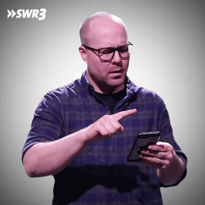 A Man In A Blue Plaid Shirt Is Pointing At A Cell Phone With Swr3 Written On The Bottom GIF