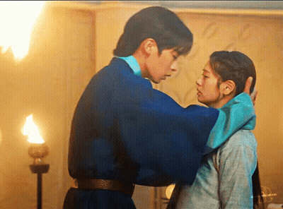 A Man In A Blue Robe Is Touching A Woman 'S Forehead . GIF