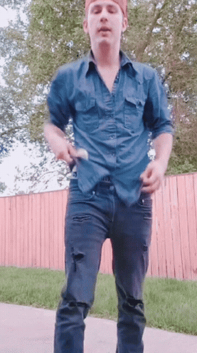 A Man In A Blue Shirt And Black Jeans Is Dancing GIF