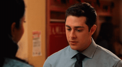 A Man In A Blue Shirt And Black Tie Looks At A Woman GIF