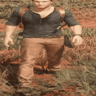 A Man In A Blue Shirt And Brown Pants Is Walking In The Grass GIF