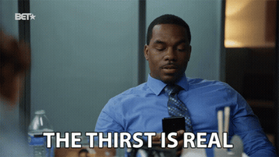 A Man In A Blue Shirt And Tie Is Holding A Cell Phone And Says " The Thirst Is Real " GIF