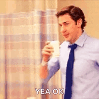 A Man In A Blue Shirt And Tie Is Holding A Cup Of Coffee And Saying `` Yea Ok '' . GIF