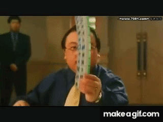 A Man In A Blue Shirt And Tie Is Holding A Stack Of Playing Cards GIF
