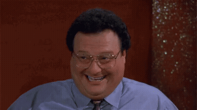A Man In A Blue Shirt And Tie Is Laughing . GIF