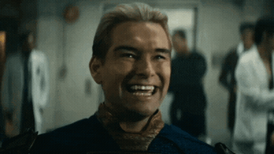 A Man In A Blue Shirt And Tie Is Laughing In A Room With Other People . GIF