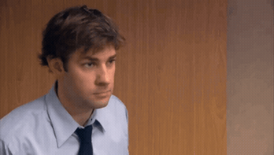A Man In A Blue Shirt And Tie Is Looking At Something . GIF
