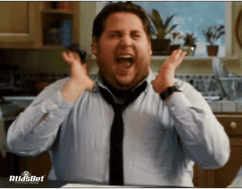 A Man In A Blue Shirt And Tie Is Screaming In A Kitchen With Atlasbet Written On The Bottom GIF