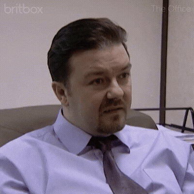 A Man In A Blue Shirt And Tie Is Sitting In A Chair . GIF