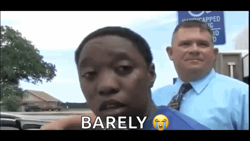 A Man In A Blue Shirt And Tie Is Standing Next To Another Man And Says Barely GIF