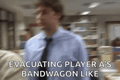 A Man In A Blue Shirt And Tie Is Walking In An Office And Says Evacuating Player A 'S Bandwagon Like GIF