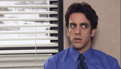 A Man In A Blue Shirt And Tie Stands In Front Of A Window GIF