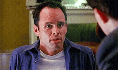 A Man In A Blue Shirt And White T-Shirt Is Talking To Another Man GIF