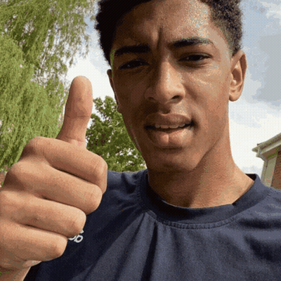 A Man In A Blue Shirt Gives A Thumbs Up Sign GIF