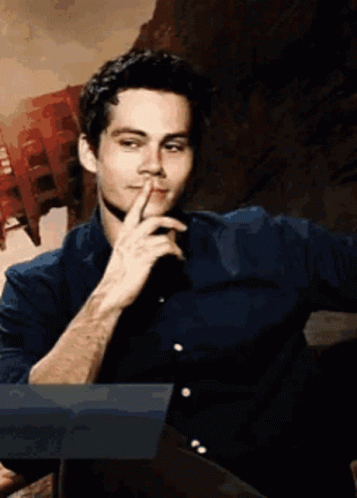 A Man In A Blue Shirt Has His Finger On His Lips GIF