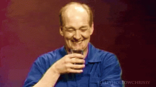A Man In A Blue Shirt Holds A Glass Of Wine GIF