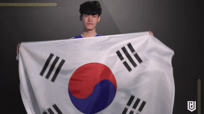 A Man In A Blue Shirt Holds A Korean Flag In His Hands GIF