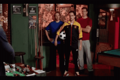 A Man In A Blue Shirt Holds A Soccer Ball While Standing Next To Two Other Men GIF