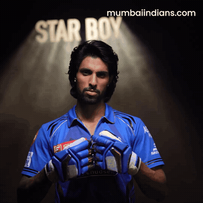 A Man In A Blue Shirt Holds His Gloves In Front Of A Star Boy Sign GIF